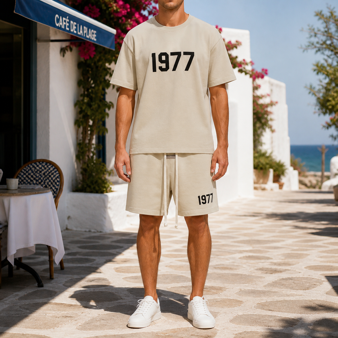 Beżowy uniseks zestaw z T-shirtem i szortami 1977 – widok z przodu na letniej promenadzie
